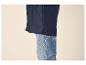 Dunkelblaue Regenjacke über hellblauen Jeans.