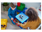 Zwei Kinder spielen mit LEGO Steinen auf einem LEGO Tisch und in LEGO Aufbewahrungsboxen.