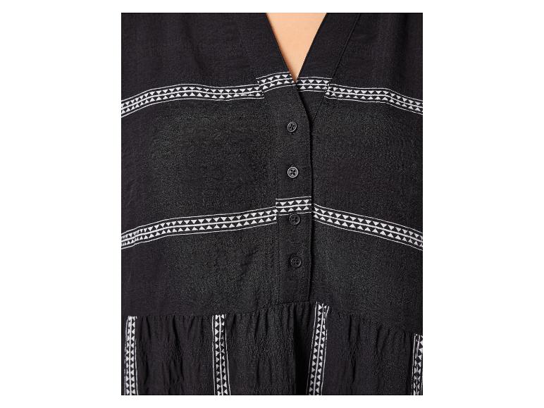 Schwarzes Kleid mit V-Ausschnitt und weißen Dreiecksdetails an Ärmeln und Saum.