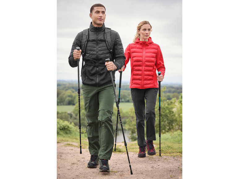 Ein Mann und eine Frau wandern mit Stöcken.