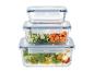 Gestapelte Glas-Frischhaltedosen mit Deckeln, gefüllt mit Salat, Gurken und Karotten.