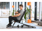 Mann benutzt eine Massagepistole auf einer Hantelbank in einem modernen Fitnessstudio.