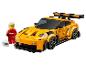 Gelbes Spielzeugauto mit Spoiler und Rennfahrerfigur mit Helm.