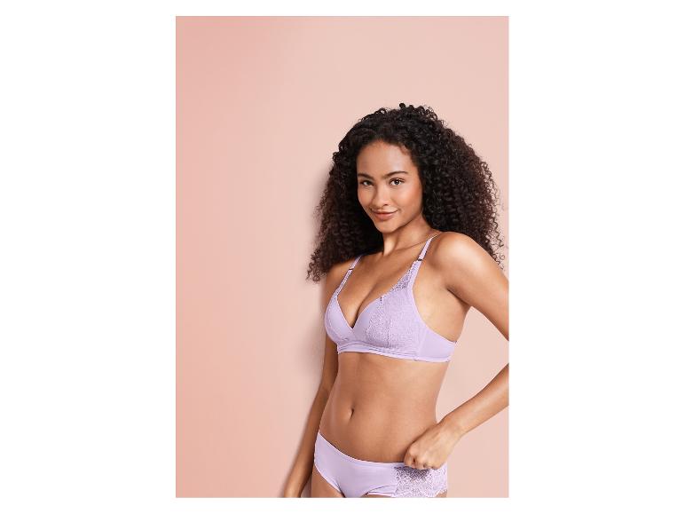 Eine Frau in einem lilafarbenen BH und Slip mit Spitze.