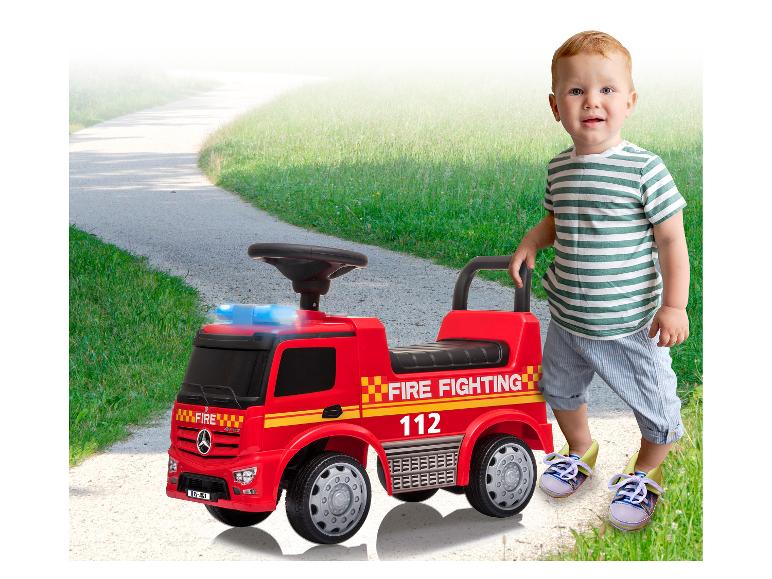 Ein kleines Kind mit einem Mercedes-Benz Feuerwehr-Spielzeugtruck.