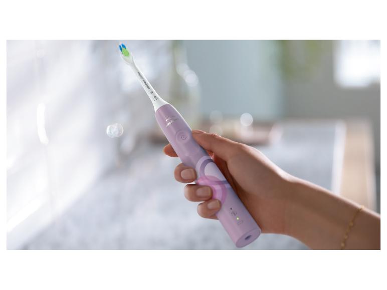 Eine Hand hält eine lavendelfarbene Philips Sonicare elektrische Zahnbürste.