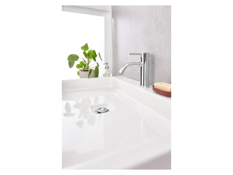 Ein weißes Waschbecken mit einem verchromten Wasserhahn und einem Seifenschälchen.