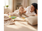 Mutter und Baby liegen auf einer Decke und lesen Kinderbücher.