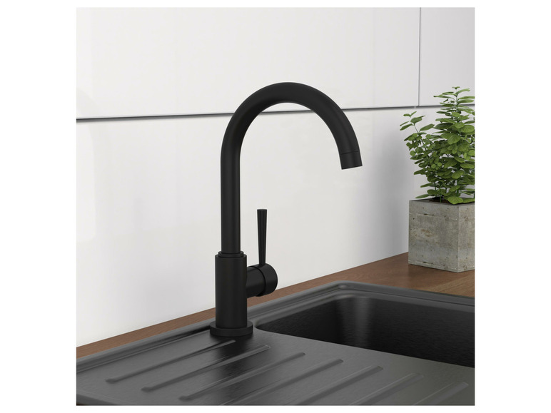 Ein schwarzer Küchenhahn über einem schwarzen Spülbecken.