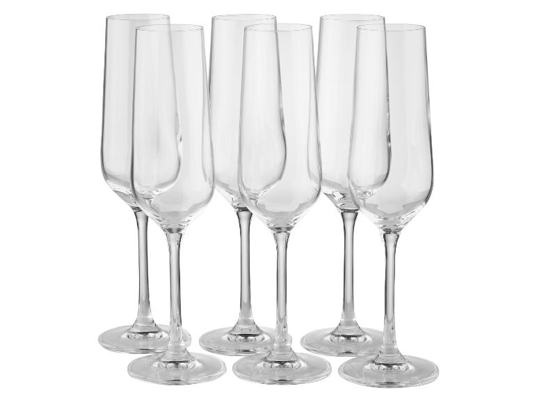Sechs transparente Champagnergläser.