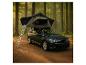Auto mit Dachzelt und Leiter in einem Wald.