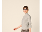 Frau in grauem Rollkragenpullover, Sonnenbrille und Hose mit Leopardenmuster.