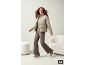 Frau in beiger Cord-Pufferjacke und brauner Ripphose.