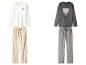 Zwei Sets gemütlicher Pyjamas: ein weißes mit Herzen und ein graues mit einem Bären.