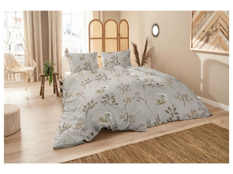 Bettwäsche mit einem floralen Muster in Braun- und Weißtönen.
