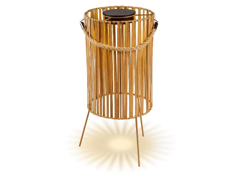 Solar-Bambuslampe mit Seilgriff und drei Beinen, die warmes Licht ausstrahlt.