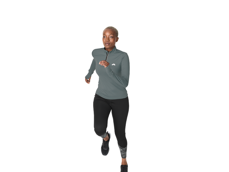 Frau in grauem Sportshirt und schwarzen Leggings läuft vor weißem Hintergrund.