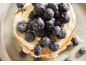 Stapel Pfannkuchen mit Blaubeeren, Sahne und Honig.
