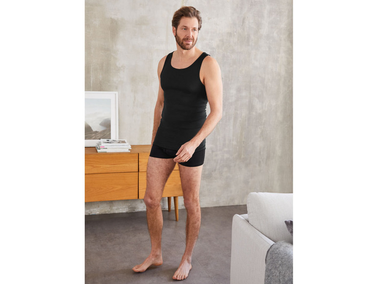 Mann in schwarzem Tanktop und Boxershorts.