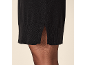 Schwarzes Strickkleid mit Schlitz und schwarze Strumpfhose.