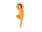 Mädchen in orangefarbenem Pyjama mit Geisterdruck, steht auf einem Bein, Hände über dem Kopf.