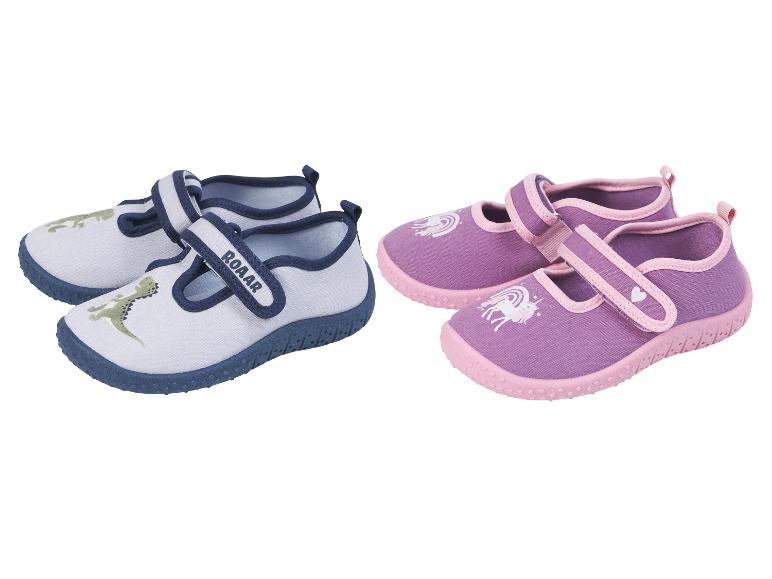 Kinderhausschuhe: blau mit Dinosaurier und lila mit Einhorn.