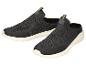 Ein Paar schwarze Slip-on-Sportschuhe mit grünen Akzenten und weißen Sohlen.