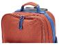 Oberer Teil einer orangefarbenen Reisetasche mit blauen Griffen und Reißverschlüssen.
