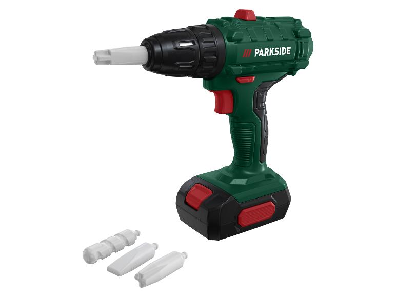 Grüner Parkside Bohrer mit weißem Zubehör auf weißem Hintergrund.