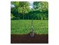 Gartenspaten steckt im Boden mit Rasen und Bäumen im Hintergrund.
