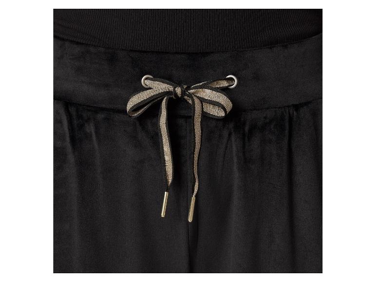 Schwarze Samthosen mit beige-schwarzen Schnürsenkeln.