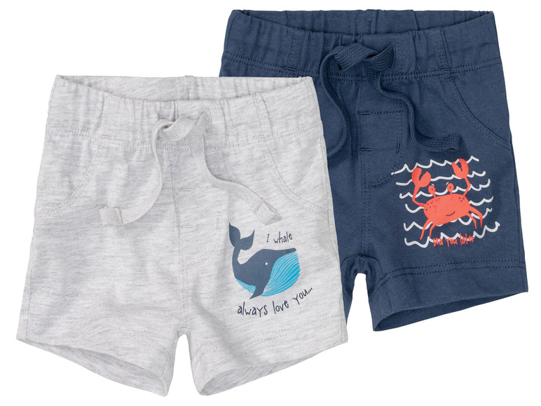 Zwei Paar kurze Hosen für Jungen mit einem Wal- und einem Krabben-Motiv.
