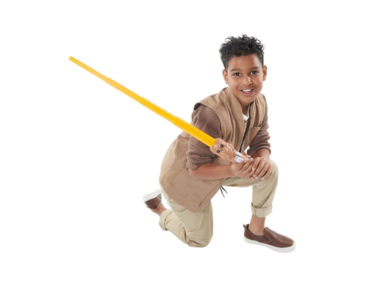 Ein Junge in brauner Kleidung mit einem Star Wars Lichtschwert.