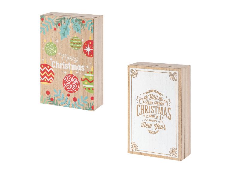 Zwei Holzschilder mit Weihnachtsmotiven, eines mit bunten Ornamenten und eines mit Text.