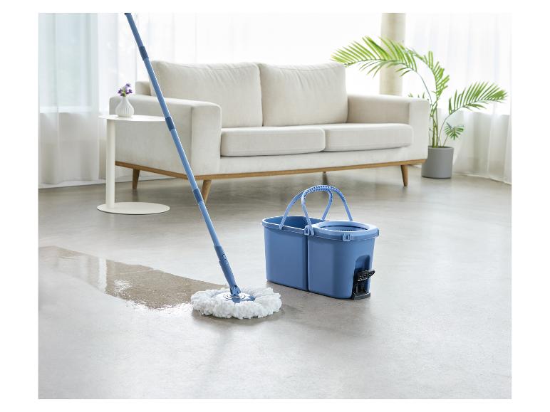 Wischmopp und Eimer reinigen einen Boden im Wohnzimmer