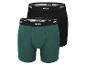 Zwei Paar Boxershorts der Marke Mexx, eine grüne und eine schwarze.