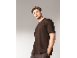 Mann in braunem T-Shirt und Hose posiert vor grauem Hintergrund.