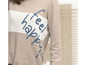 Beigefarbener Pullover mit horizontalen Streifen und dem Schriftzug 'feel happy'.