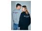 Mann und Frau von hinten, in grauen und schwarzen Sweatshirts mit der Aufschrift „STRENESSE BLUE“.