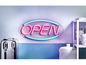 Ein Neon-Schild mit der Aufschrift 'Geöffnet' mit einer Kaffeemaschine und einer Keksdose