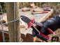 Person mit Handschuhen schneidet Draht mit Zange an einem Holzpfosten.