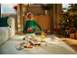 Kind in Weihnachtspullover spielt mit Holzeisenbahn und Bauspielzeug.