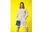 Lächelnde Frau in weißem T-Shirt und Shorts mit bunten Taschen.