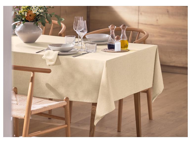 Tisch mit beiger Tischdecke, Geschirr, Blumenvase und Gewürzen gedeckt.