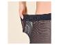Frau zieht am elastischen Bund einer schwarzen Strumpfhose.