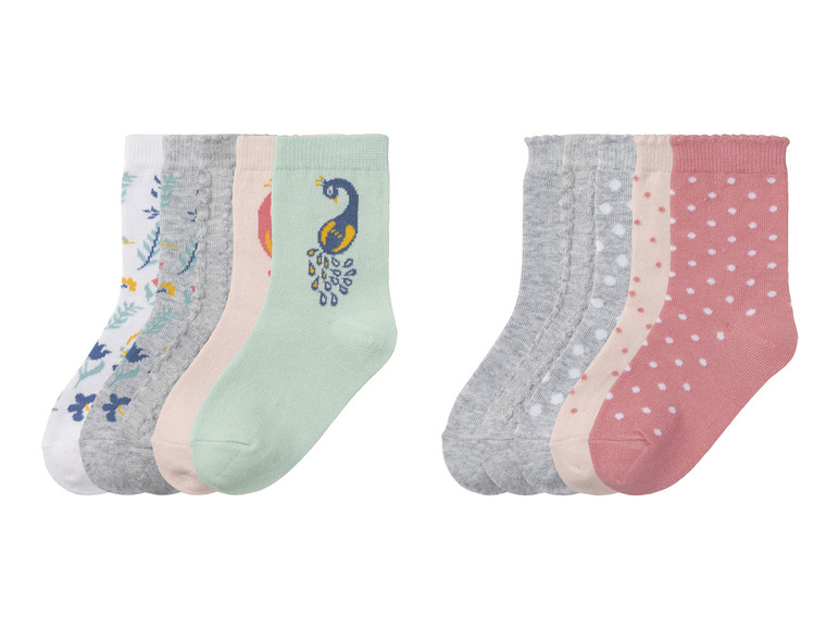 Sechs Paar Socken mit verschiedenen Mustern: Blumen, Punkte und ein Pfau.