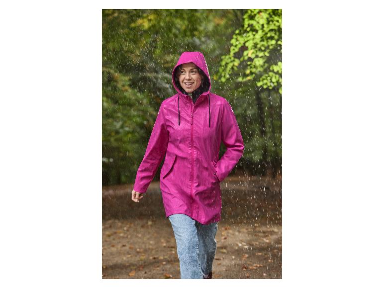 Eine Frau im rosa CRIVIT Damen-Regenparka läuft im Regen.