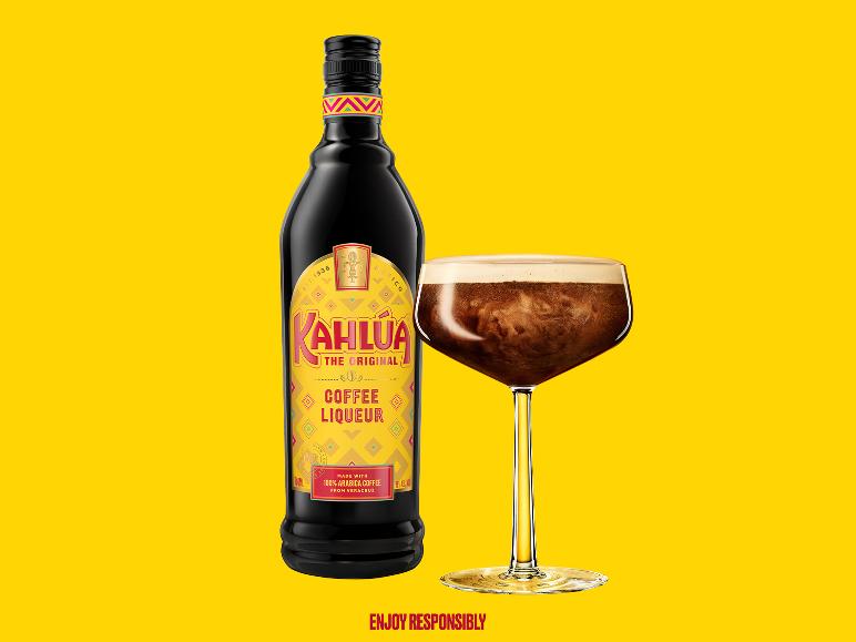 Kaffeelikörflasche und Cocktailglas mit Kaffeegetränk auf gelbem Hintergrund.