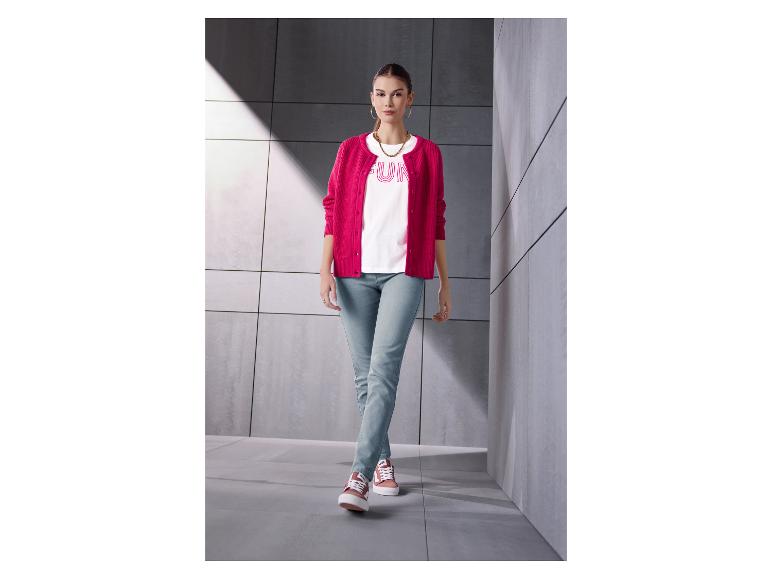 Frau in pinker Strickjacke, weißem T-Shirt mit „FUN“ und heller Jeans.