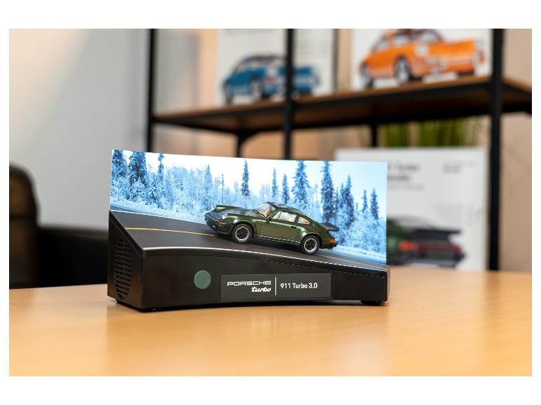 Ein Porsche 911 Turbo 3.0 Automodell auf einem Ständer mit Winterhintergrund.